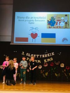 czwórka dzieci na scenie przedstawia prezentację dotyczącą projektu Glony dla przyszłości