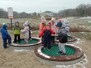 grupa dzieci skacze na trampolinach