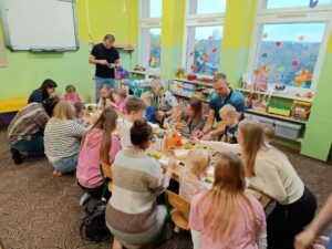 rodzice i ich dzieci robią sałatki owocowe