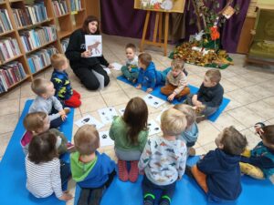 Dzieci oglądają zdjęcia leśnych zwierząt i ich śladów