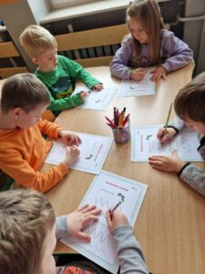 Dzieci poprawiają po linii lub po śladzie szlaczki.