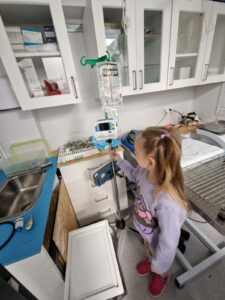 Dziecko ogląda maszynę w przychodni weterynaryjnej.