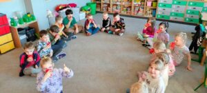 Dzieci piją z kubeczków koktajl owocowy