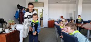 Chłopiec trzyma w ręku butelkę z małym wiatraczkiem
