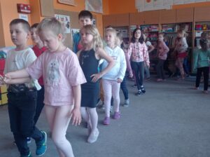 sala przedszkolna i grupa stojących dzieci