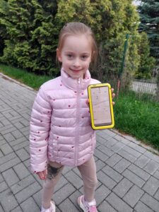 Dziewczynka pokazuje na telefonie dystans pokonany podczas spaceru