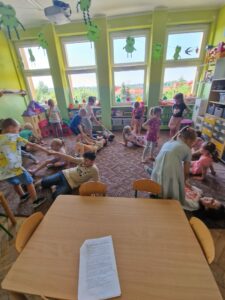 Dzieci uczestniczą w zabawie ruchowej: ,,Pomóż przyjacielowi"