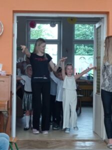 dziecko i pani instruktorką stoją w drzwiach sali