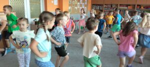 Dzieci idą po dywanie z rękoma na biodrach