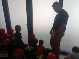 strażak pokazuje salę z dymem