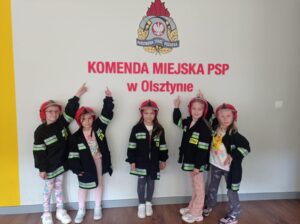 dziewczynki na tle napisu komenda straży pożarnej