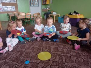 grupa dzieci siedzi na dywanie