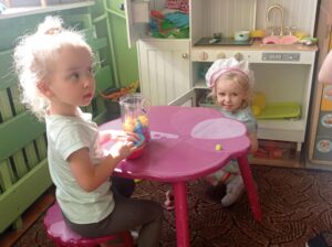 dwie dziewczynki bawią się w kąciku kuchennym
