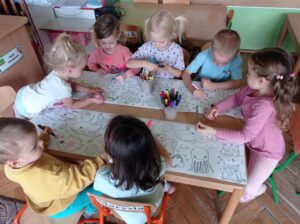 grupa dzieci koloruje wspólną kolorowankę