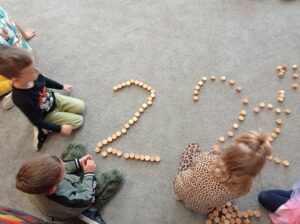 dzieci układają z klocków cyfrę 2