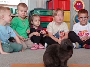 Królik siedzi w środku koła dzieci