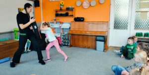 Dziewczynka wykonuje gest ochronny przed uderzeniem w głowę