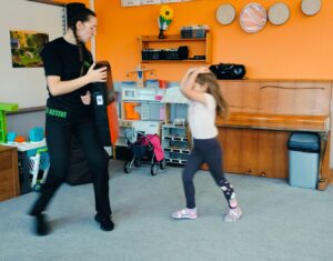 Dziewczynka wykonuje gest ochronny przed uderzeniem w głowę