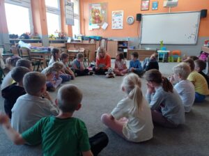 grupa dzieci w kole, dzieci słuchają czytania biblii