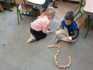 dwoje dzieci przed nimi cyfra 2 ułożona z klocków