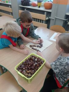 trzech chłopców układa cyfrę 2 z ksztanów