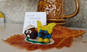 Małe ludziki z kasztanów na liściu.