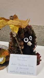 Praca plastyczna jeż z szyszek pod parasolem z liści.