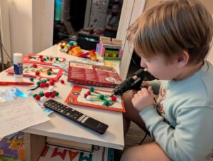 Chłopiec przykleja klejem na gorąco elementy świąteczne