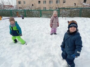 grupa dzieci stoi na śniegu
