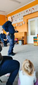 Policjant pokazuje dzieciom, w którym miejscu trzyma broń