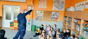 Policjant pokazuje dzieciom tzw lizak policyjny