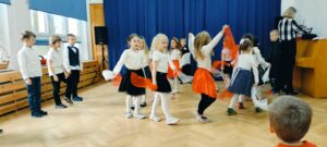 Dziewczynki tańczą w kółku z chustami