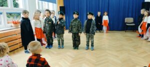 Czworo chłopców ubranych w stroje wojskowe stoi z przodu sceny