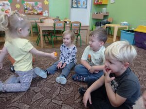 dziewczynka daje mandarynkę koleżance