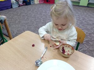 dziewczynka smaruje kanapkę dżemem