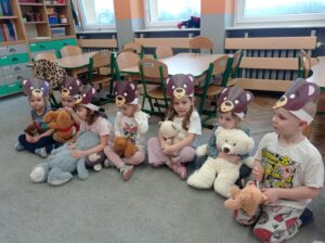 grupa dzieci w maskach misiów, trzyma w ręku swoje misie