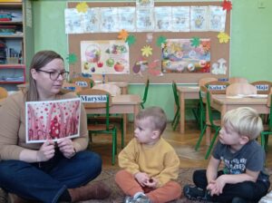 prowadząca pokazuje obrazek artystki, dzieci patrzą