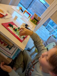 Chłopiec przykleja elementy świąteczne