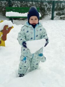 chłopiec trzyma bryłę śniegu