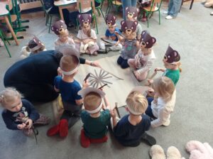 grupa dzieci przykleja paski na kartkę