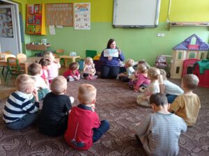 pracownik księgarni czyta dzieciom