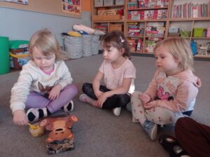 trzy dziewczynki siedzą na dywanie