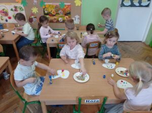 dzieci naklejają kropki na szblon grzyna