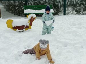 dwoje dzieci bawi się na śniegu