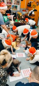 rodzice i dzieci wypełniają na dywanie kartę pracy