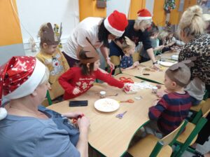 grupa dzieci i rodziców wykonuje renifera z dostępnych materiałów