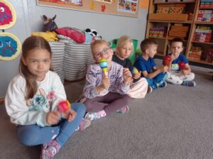 kilkoro dzieci trzyma w ręku grzechotki