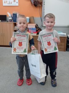 dwóch chłopców trzyma dyplomy