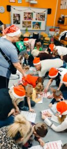 rodzice i dzieci wypełniają na dywanie kartę pracy