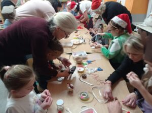 grupa dzieci i rodziców wykonuje renifera z dostępnych materiałów